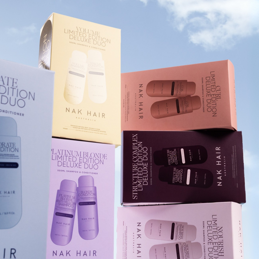 Nak Hair product packaging against a blue sky with clouds